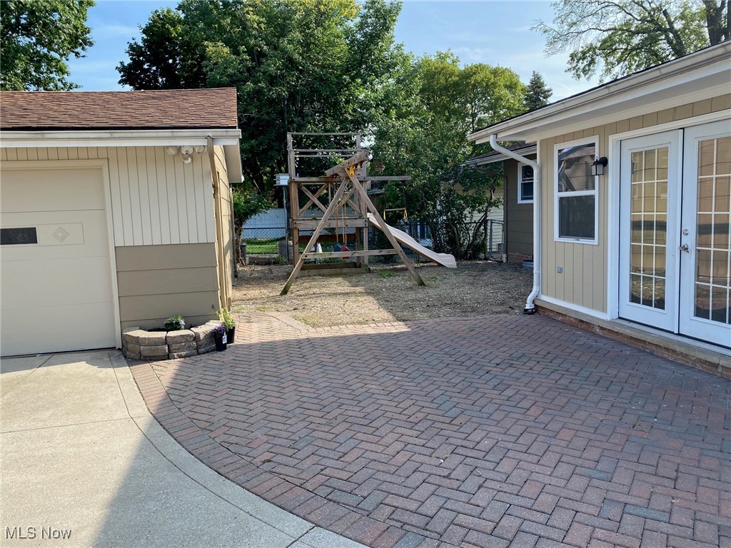 6261 Springwood Road Cleveland, OH 44130 - Photo 2 of 27 View of patio with a garage, a playground, and french doors