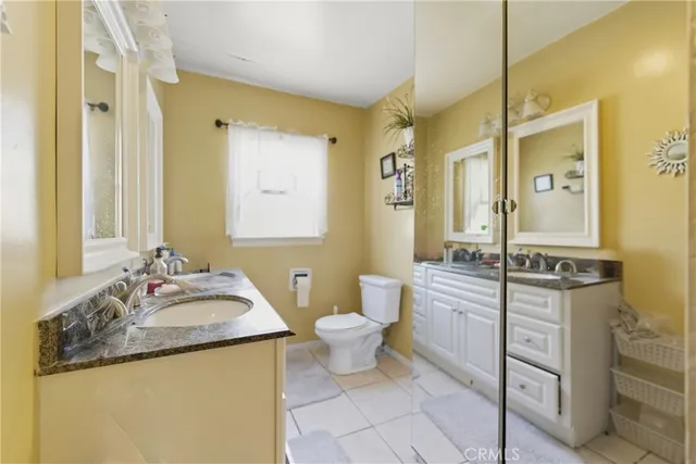 a bathroom with a granite countertop sink mirror vanity and toilet
