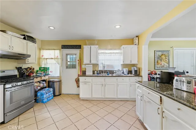 a kitchen with granite countertop white cabinets and white appliances