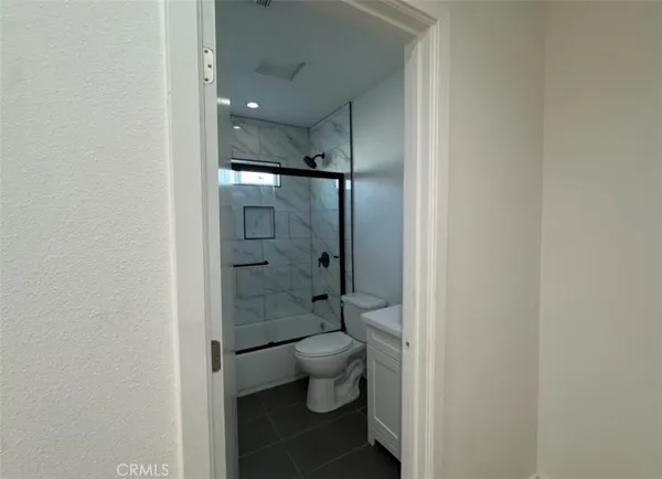 a bathroom with a granite countertop toilet a sink and shower