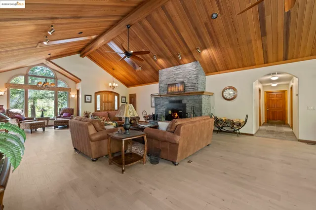 a kitchen with stainless steel appliances granite countertop a kitchen island a stove a sink a refrigerator and blue cabinets with wooden floor