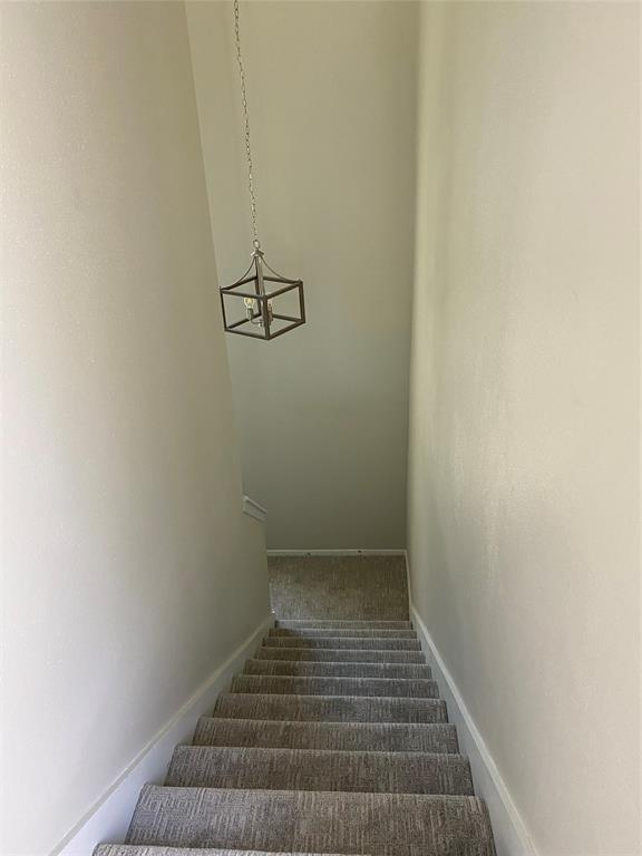 3936 Travis Street Dallas, TX 75204 - Photo 2 of 17 Carpeted staircase featuring a contemporary metal chandelier