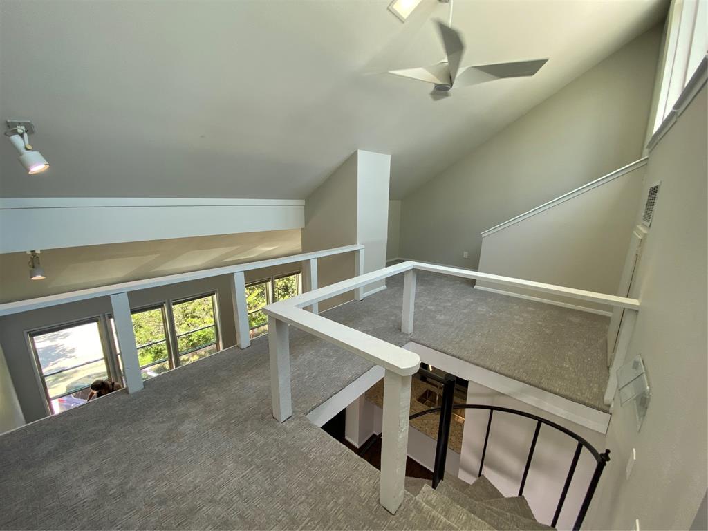 3936 Travis Street Dallas, TX 75204 - Photo 7 of 17 Upper-level loft space featuring light gray carpeting, crisp white railings, and track lighting