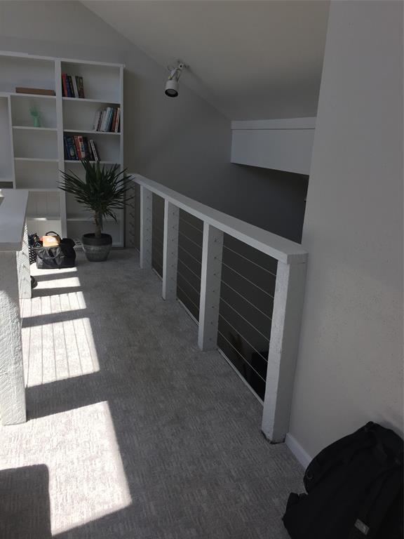 3936 Travis Street Dallas, TX 75204 - Photo 9 of 17 Open loft area featuring a contemporary cable railing system and integrated built-in shelving