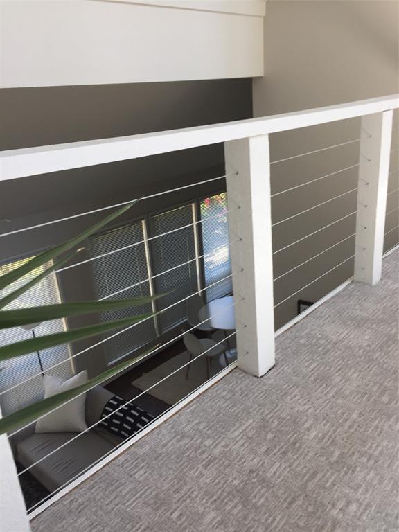 3936 Travis Street Dallas, TX 75204 - Photo 10 of 17 Open concept interior featuring a contemporary cable railing system and light-toned, textured carpeting