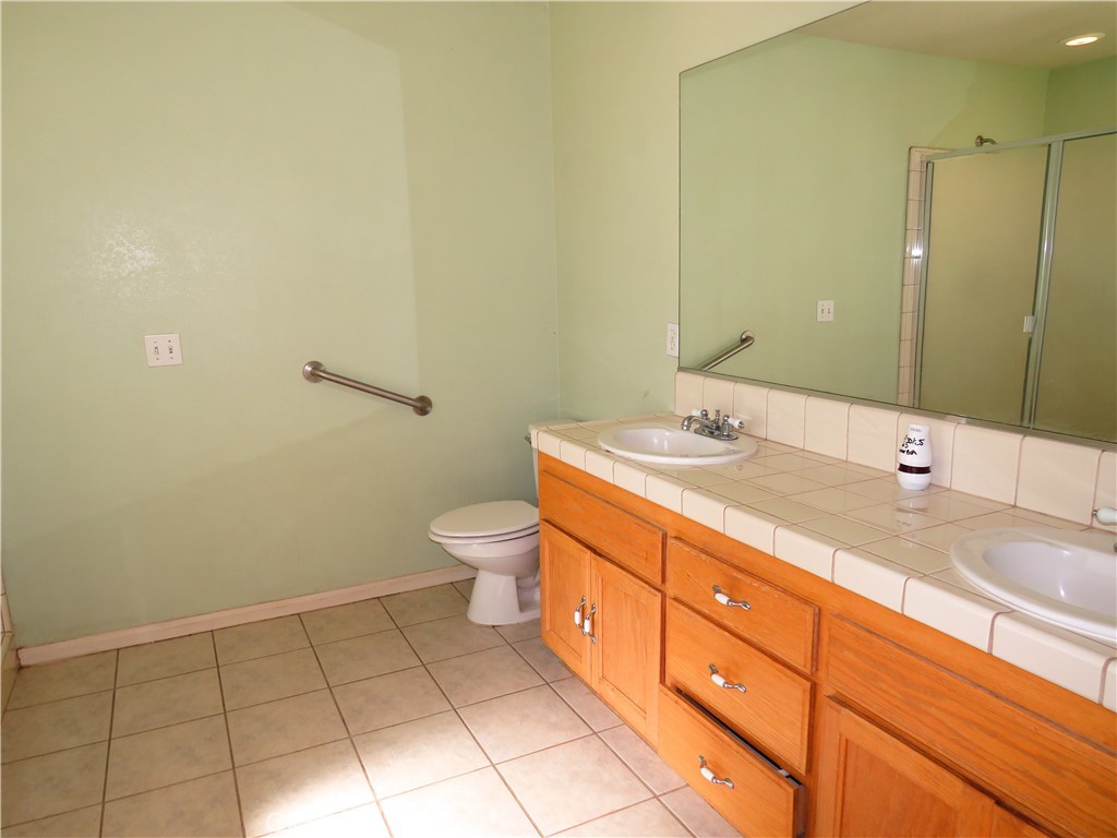 9951 Arrowhead Road Phelan, CA 92371 - Photo 14 of 21 a bathroom with a granite countertop sink a toilet and a mirror