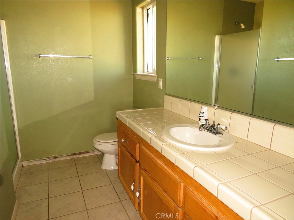 9951 Arrowhead Road Phelan, CA 92371 - Photo 18 of 21 a bathroom with a sink a toilet and shower