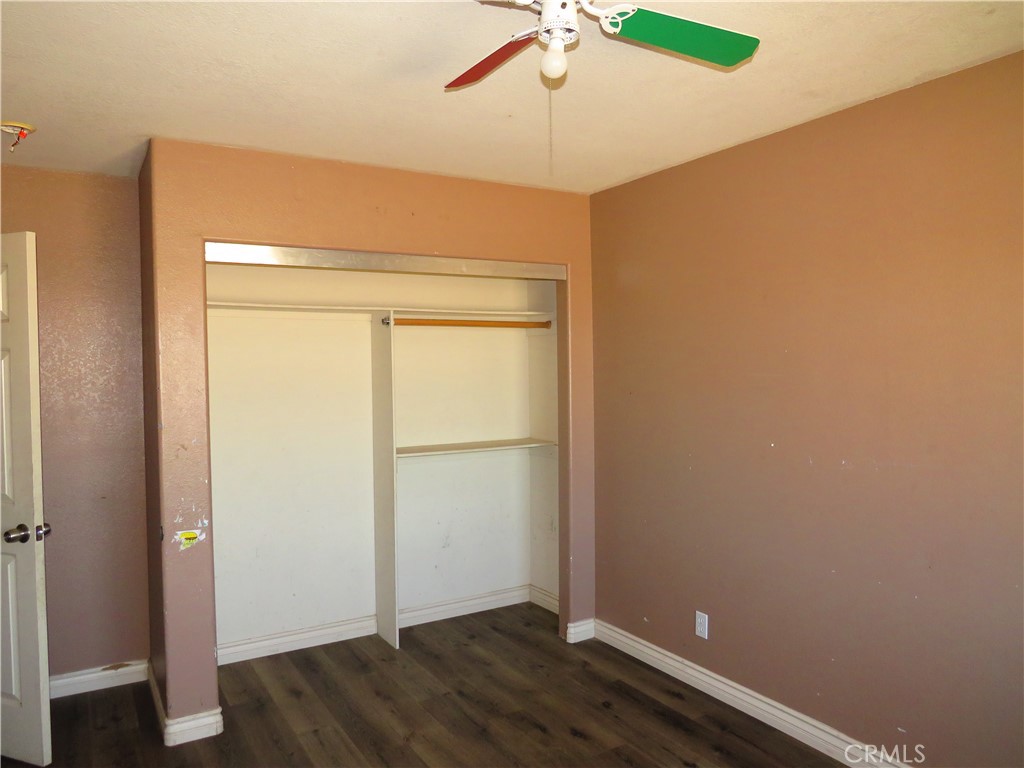 9951 Arrowhead Road Phelan, CA 92371 - Photo 20 of 21 an empty room with wooden floor and fan