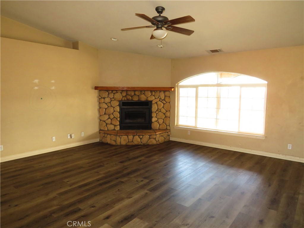 9951 Arrowhead Road Phelan, CA 92371 - Photo 9 of 21 a view of empty room with wooden floor and fireplace