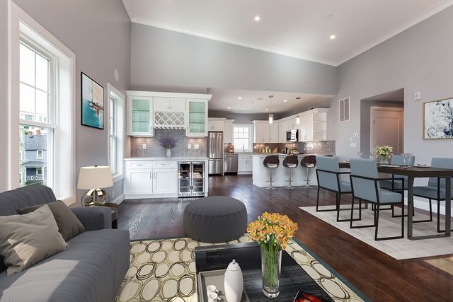 a living room with furniture kitchen view and a large window