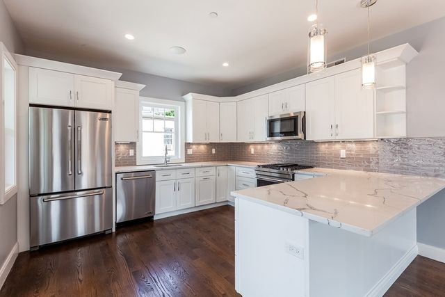 a kitchen with granite countertop white cabinets and stainless steel appliances