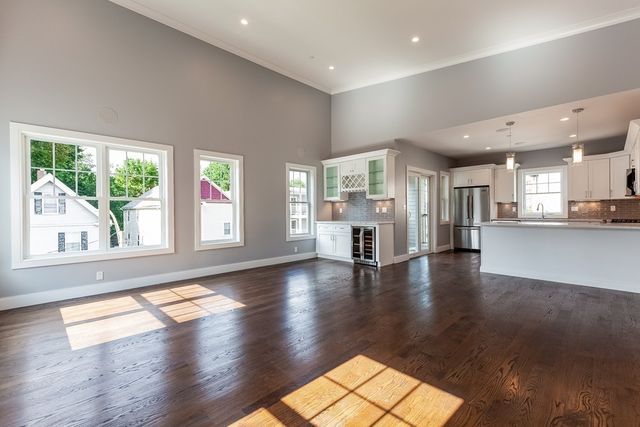a view of empty room with wooden floor and windows