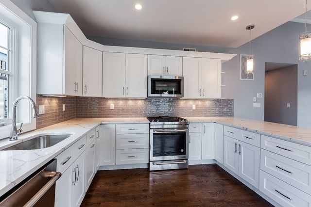 a kitchen with stainless steel appliances granite countertop a sink stove and cabinets