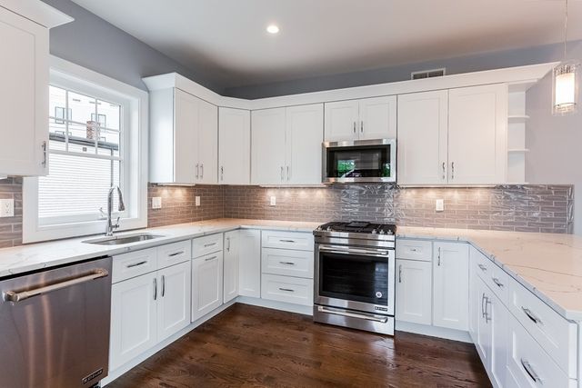 a kitchen with granite countertop white cabinets and appliances