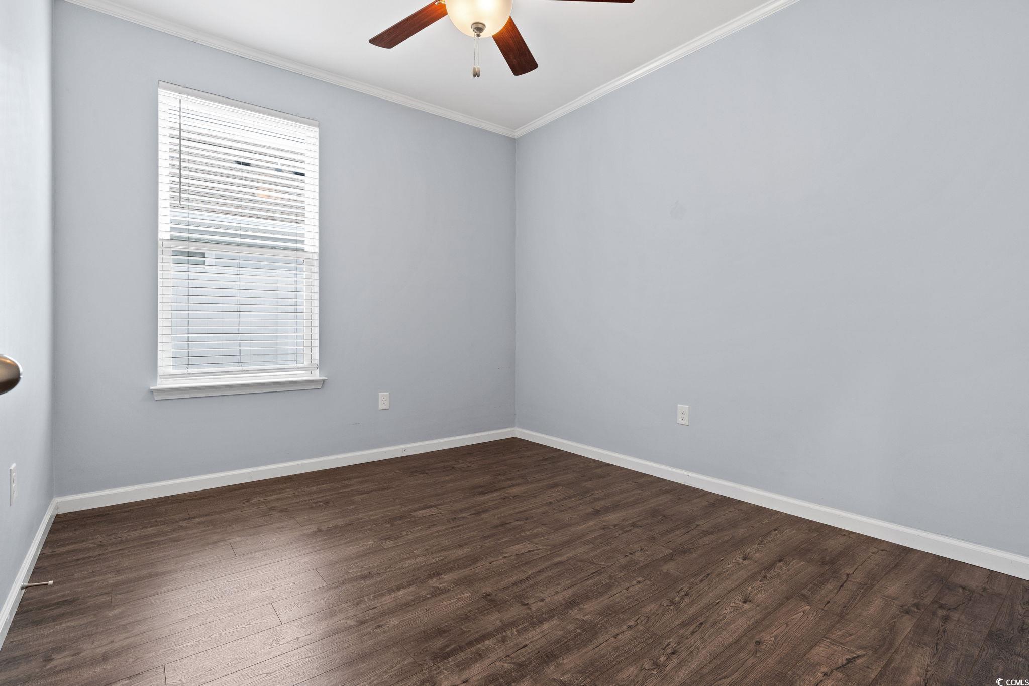 797 Salerno Circle, Unit C Myrtle Beach, SC 29579 - Photo 26 of 40 Unfurnished room with crown molding, dark wood-type flooring, and ceiling fan