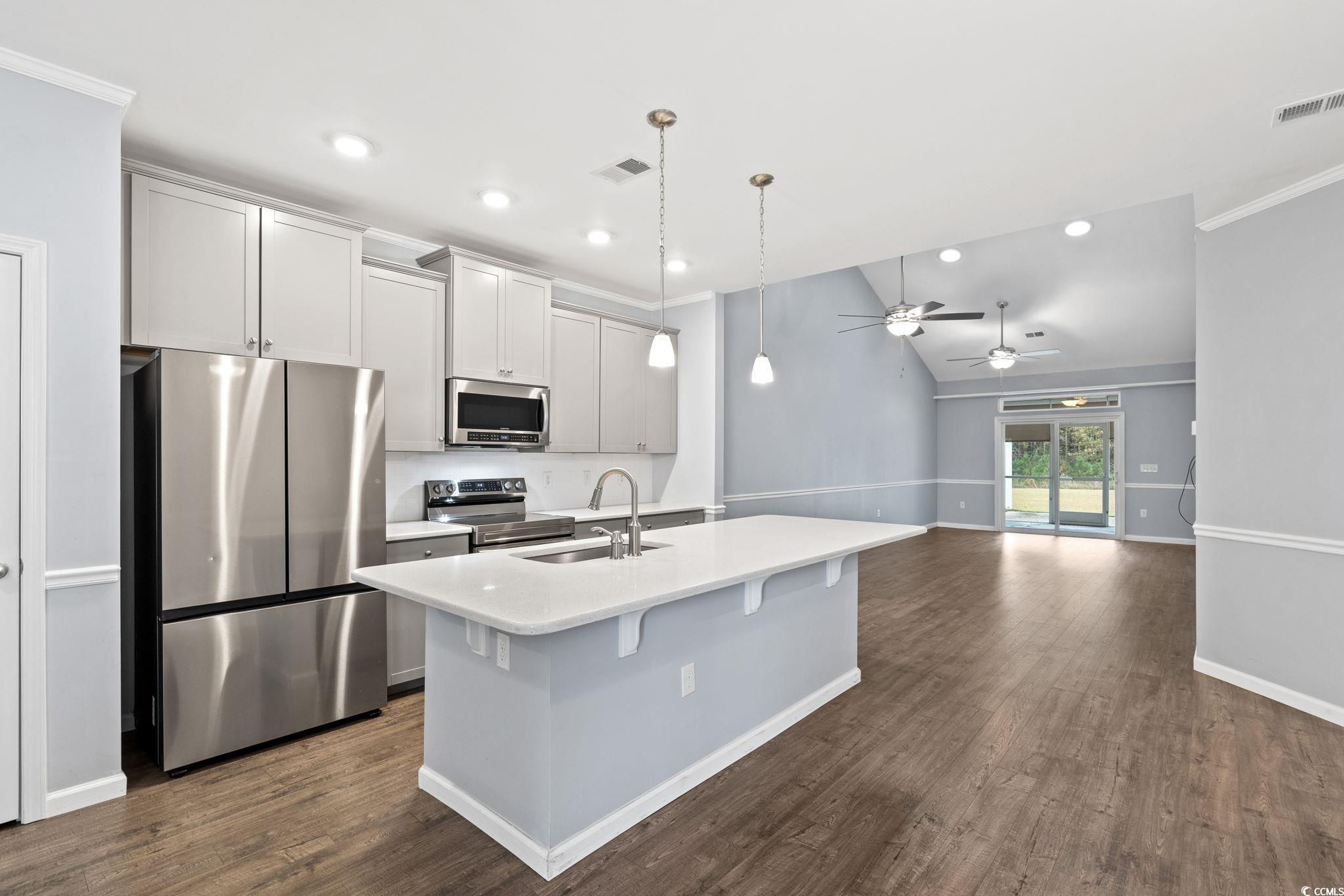 797 Salerno Circle, Unit C Myrtle Beach, SC 29579 - Photo 3 of 40 Kitchen with appliances with stainless steel finishes, decorative light fixtures, dark wood finished floors, crown molding, and recessed lighting