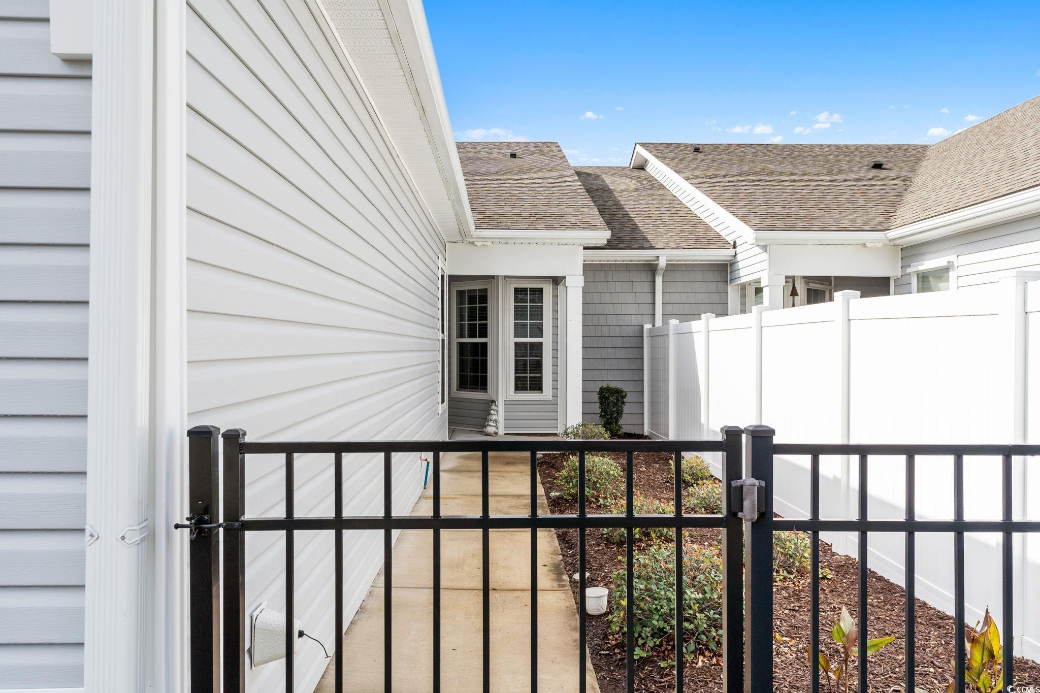 797 Salerno Circle, Unit C Myrtle Beach, SC 29579 - Photo 40 of 40 Doorway to property featuring a gate and a shingled roof