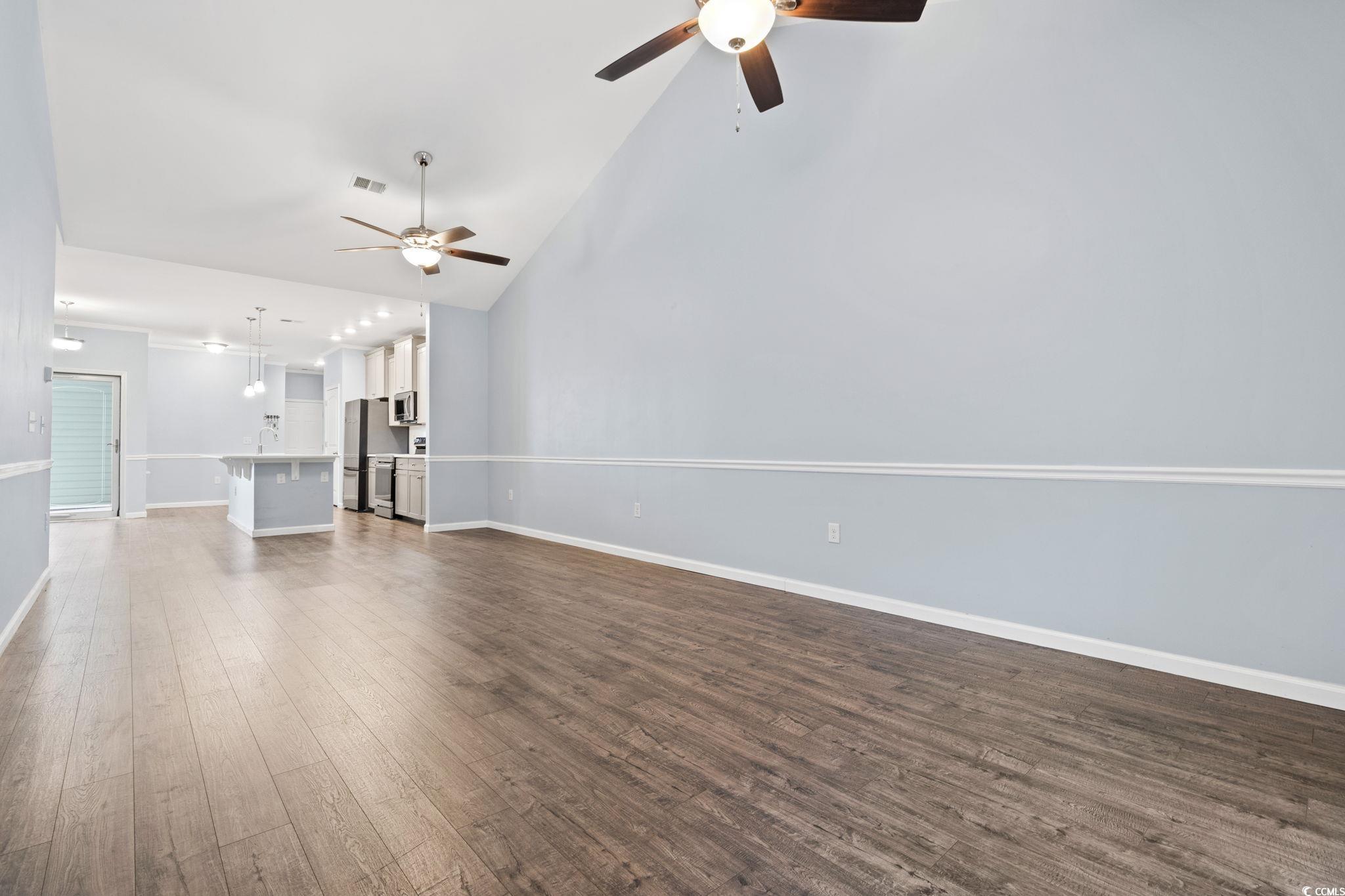 797 Salerno Circle, Unit C Myrtle Beach, SC 29579 - Photo 9 of 40 Unfurnished living room with a ceiling fan, high vaulted ceiling, and dark wood-style flooring