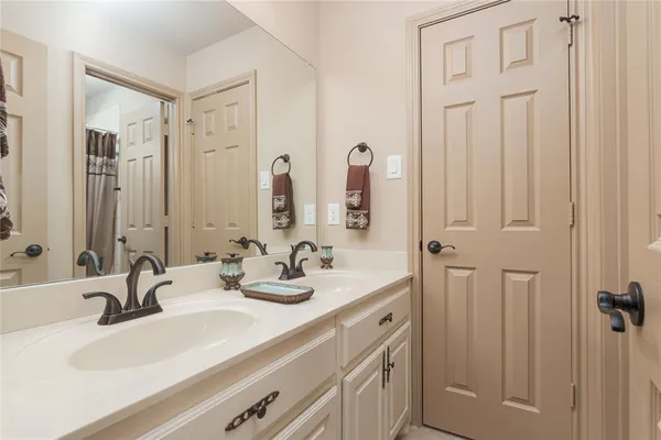 a bathroom with double vanity sinks and a mirror