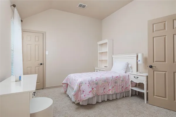 a bedroom with a bed and a table chair
