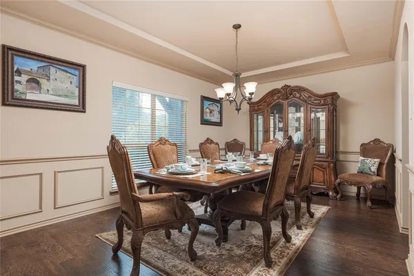 a view of a dining room with furniture a chandelier and wooden floor