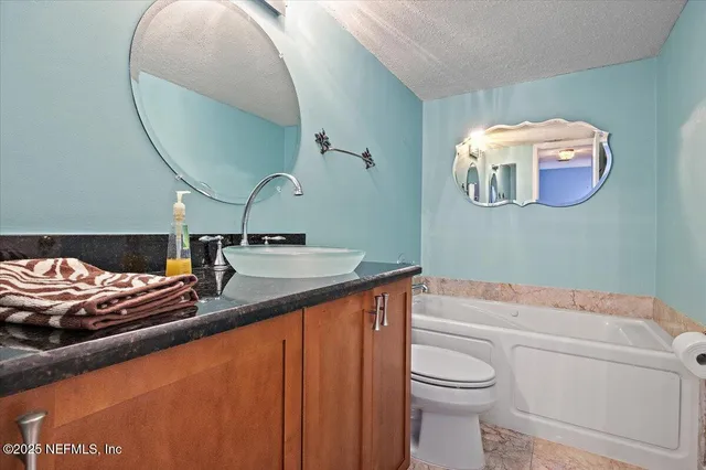 a bathroom with a sink a toilet and a mirror
