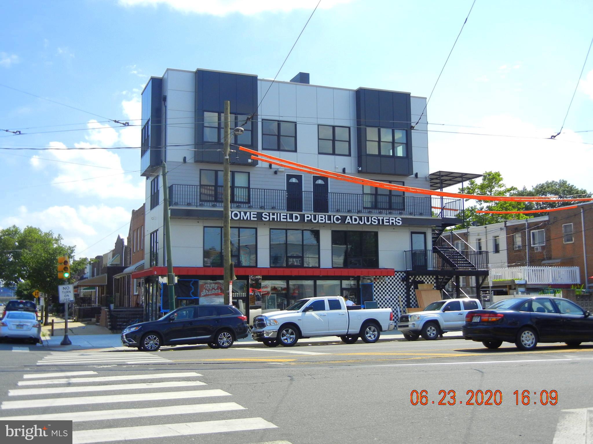 a view of street with large building and cars parked on road