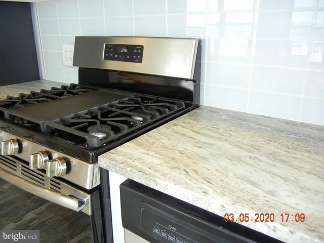 a kitchen with stainless steel appliances granite countertop a stove and a sink