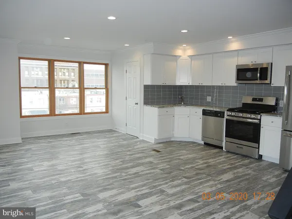 a kitchen with stainless steel appliances a stove top oven and a refrigerator