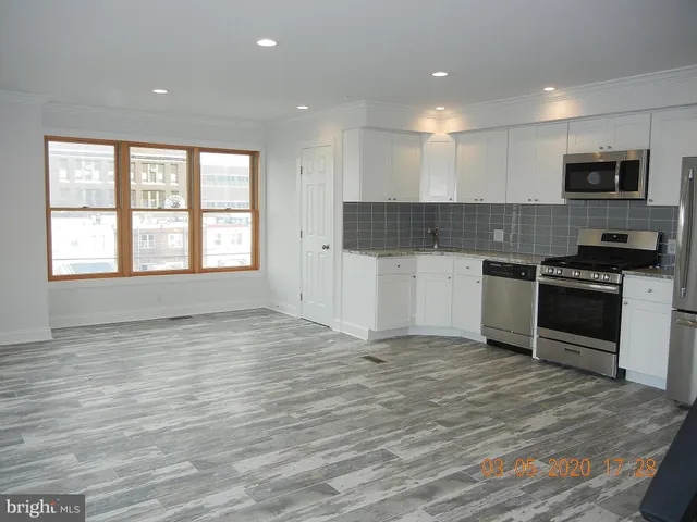 a kitchen with stainless steel appliances a stove top oven and a refrigerator