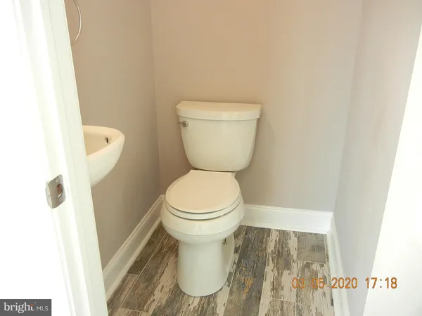an empty room with wooden floor and fan