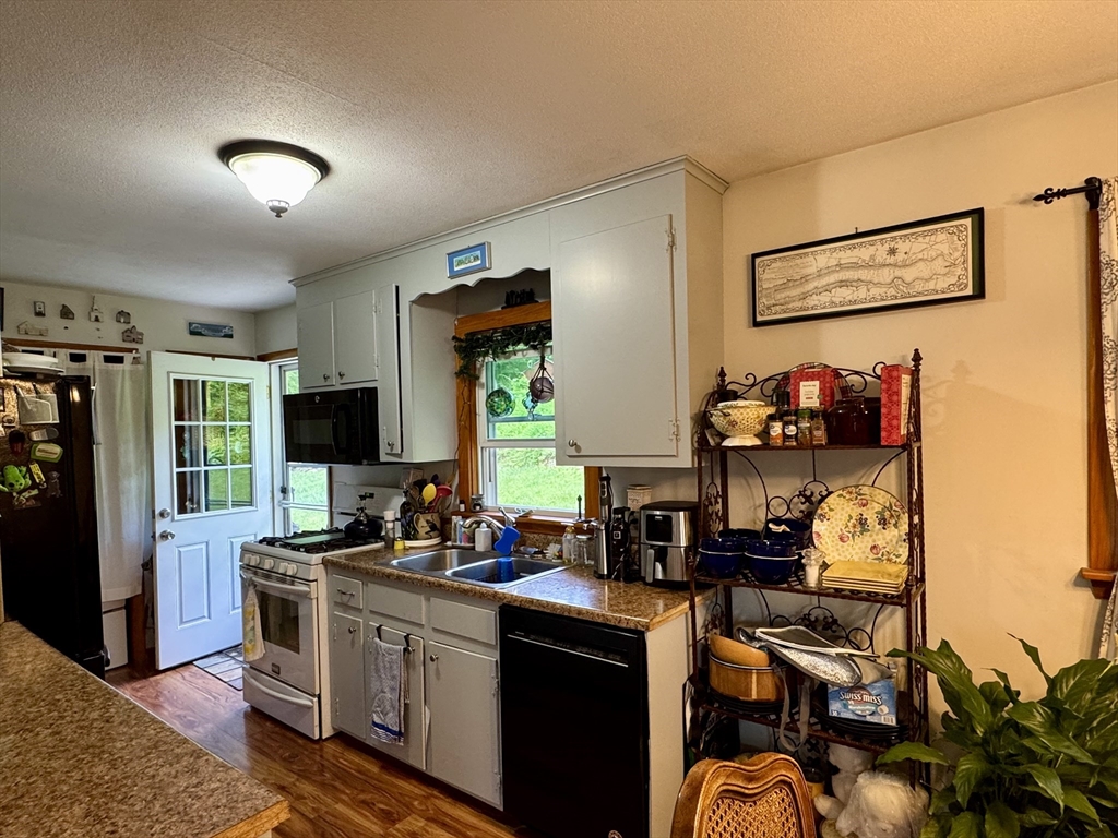 171 Haydenville Road Whately, MA 01093 - Photo 13 of 24 a kitchen with stainless steel appliances granite countertop a stove top oven a sink and a refrigerator