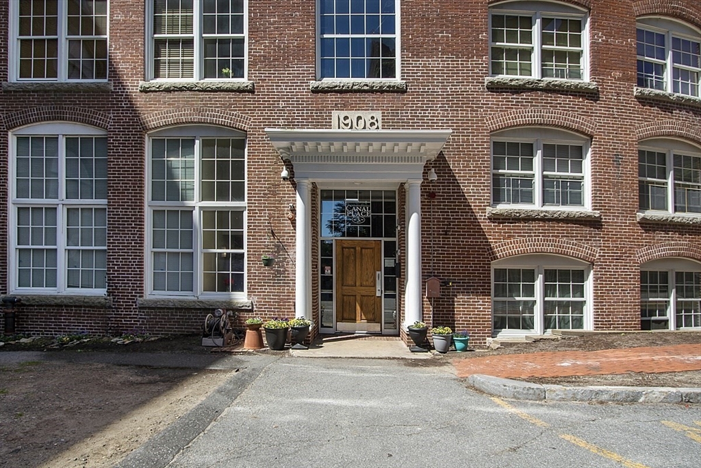200 Market Street, Unit 4504 Lowell, MA 01852 - Photo 13 of 19 a front view of a brick building with a yard