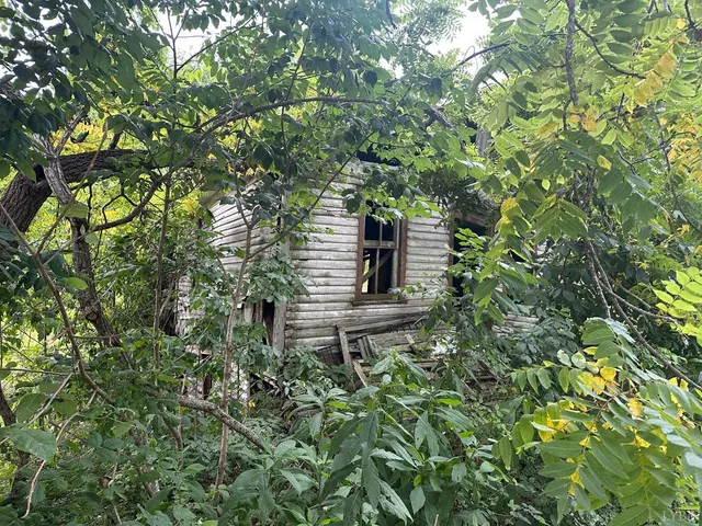 a backyard of a house with lots of green space and a fountain