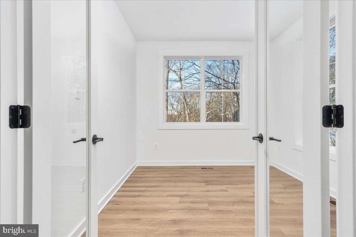 13935 Harrisville Road Mount Airy, MD 21771 - Photo 13 of 73 a view of an empty room with wooden floor and a window