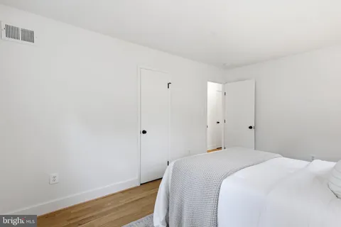 a bedroom with a bed and wooden floor