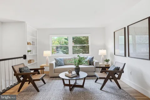 a living room with furniture and a potted plant on a table