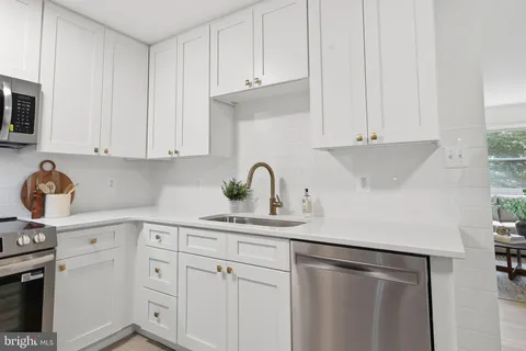 a kitchen with white cabinets and sink