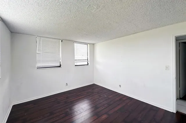 a view of a room that has wooden floor and windows in it