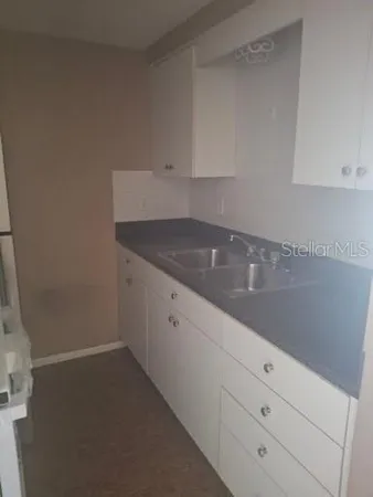 a kitchen with white cabinets and a sink