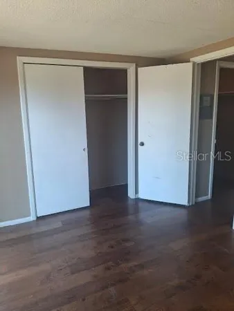 an empty room with wooden floor and closet