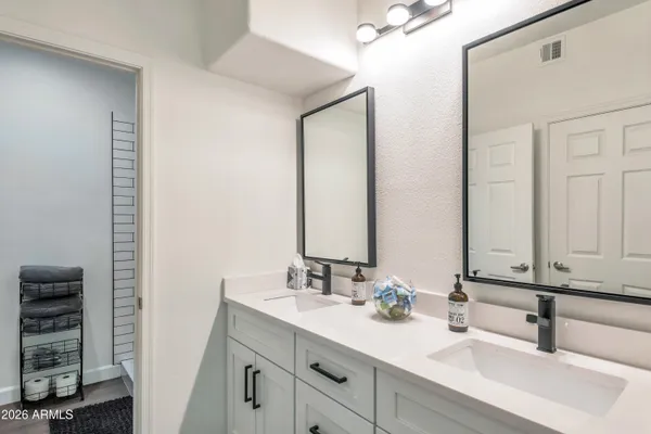 a bathroom with a double vanity sink and a mirror