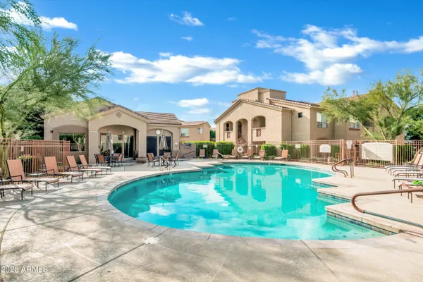 a front view of a house with swimming pool having outdoor seating