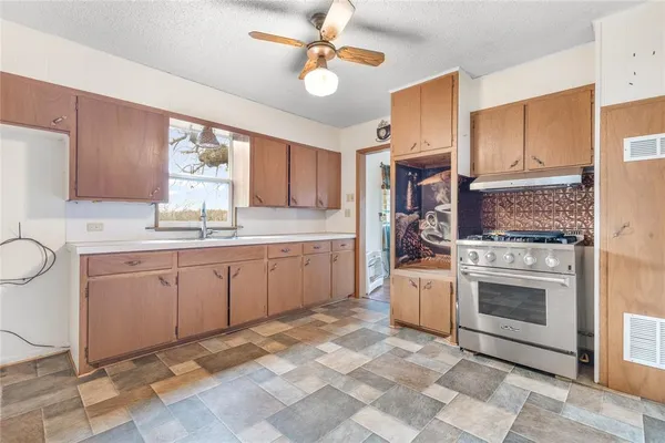 a kitchen with a stove top oven sink and cabinets