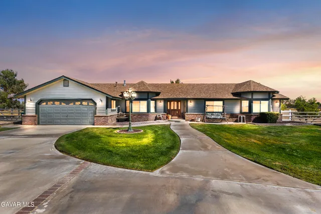 a view of a house with a yard and potted plants