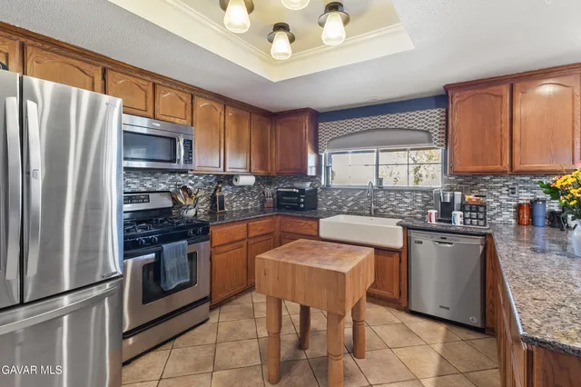 a kitchen with stainless steel appliances granite countertop a stove refrigerator sink and cabinets
