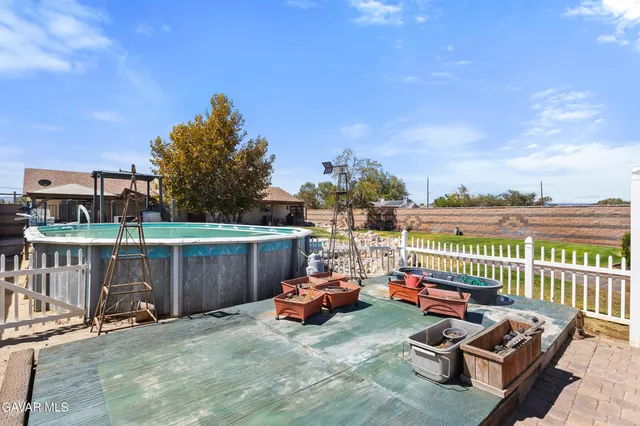 a view of a patio with couches chairs and wooden fence