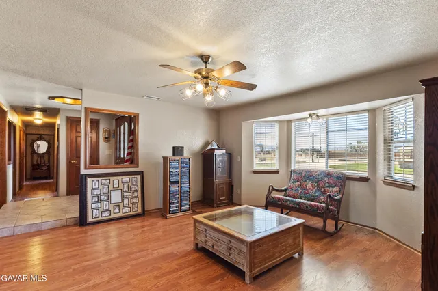 a living room with furniture a desk and a large window