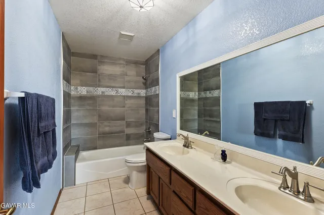 a bathroom with a double vanity sink toilet mirror and bathtub