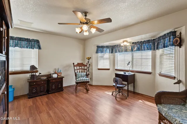 a view of a workspace with furniture and a window